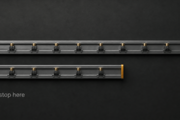 Two industrial conveyor lanes in dark graphite, the upper lane continuous and the lower lane cut short with a small amber end cap